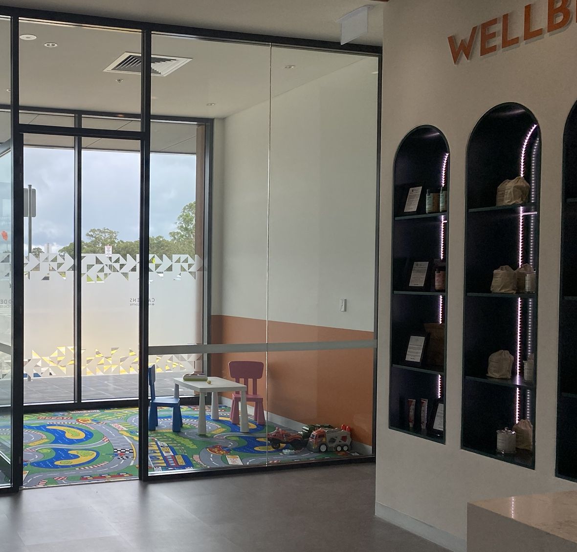 Glass-walled children's play room with small table and chairs